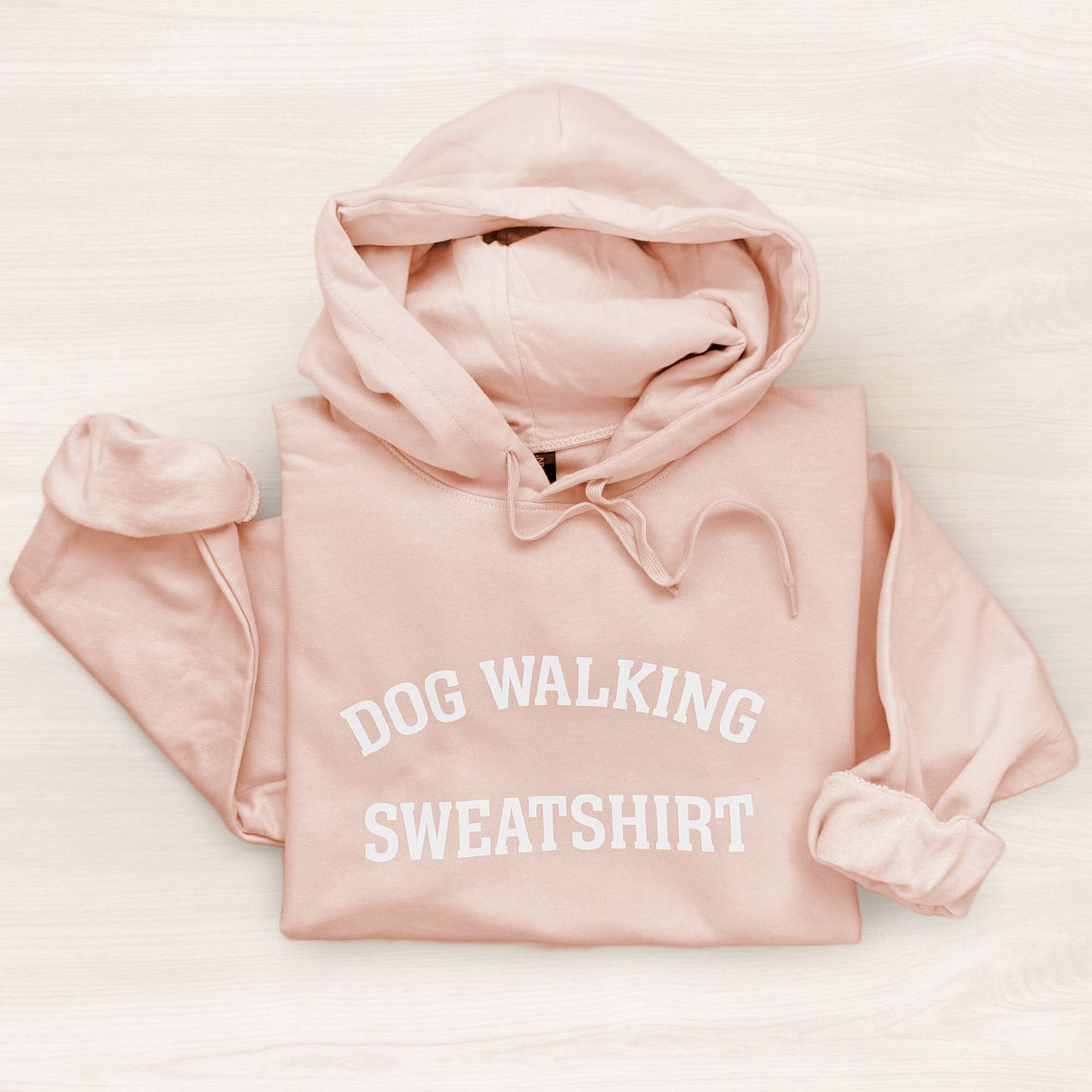 Pink sweatshirt with 'DOG WALKING SWEATSHIRT' text on a light background
