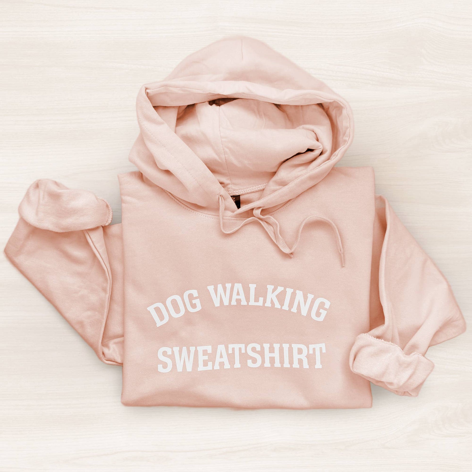 Pink sweatshirt with 'DOG WALKING SWEATSHIRT' text on a light background