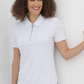 Woman wearing a white polo shirt against a plain background